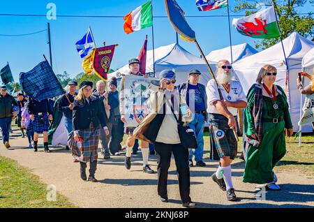 Bei der Parade der Clan-Tartane bei den Scottish Highland Games in Gulfport, Mississippi, tragen die Menschen Tartanbanner und keltische Flaggen. Stockfoto