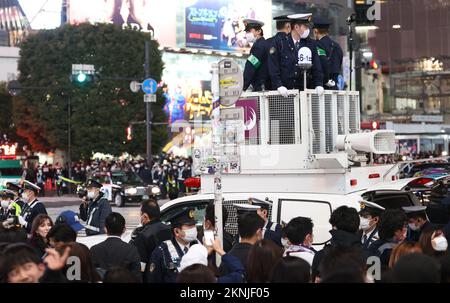 Tokio, Japan. 27.. November 2022. Polizeibeamte kontrollieren japanische Fußballfans, die sich am Freitag, den 27. November 2022, im Shibuya Modeviertel in Tokio versammeln. Japan wurde bei der FIFA-Weltmeisterschaft in Katar von Costa Rica 0-1 besiegt. Kredit: Yoshio Tsunoda/AFLO/Alamy Live News Stockfoto