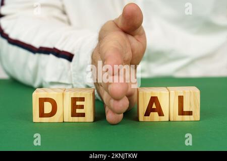 Geschäftskonzept. Ein Mann trennt die Würfel mit der Inschrift - Deal Stockfoto