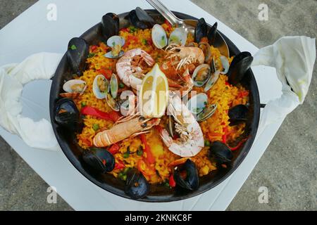 Ein Meeresfrüchte-Paella-Gericht mit Reis, dekoriert mit Muscheln und Garnelen aus nächster Nähe Stockfoto