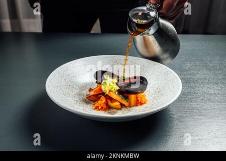 Eine Nahaufnahme mit Muschel und Lachs, serviert auf einer weißen Schüssel Stockfoto