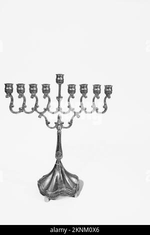 Wunderschöne silberne chanukka Menorah. Alte Kerzenmenora auf weißem Hintergrund. Jüdisches Feiertagsbanner mit Kopierraum, vertikal Stockfoto