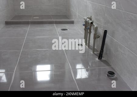 Water and sewer pipes in the new bathroom. Empty bathroom after renovation Stockfoto