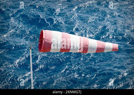 Windsocke mit turbulentem Meer im Hintergrund. Stockfoto