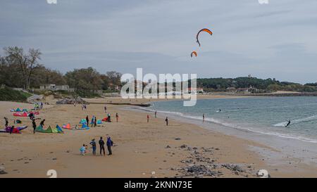 Santander, Spanien - 31. Oktober 2022: Kitesurfer und Badende am Strand Playa de los Peligros, Santander, Kantabrien Stockfoto