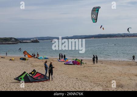 Santander, Spanien - 31. Oktober 2022: Kitesurfer und Badende am Strand Playa de los Peligros, Santander, Kantabrien Stockfoto