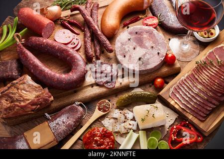 Kulinarische Hintergrundinformationen zu verschiedenen geräucherten Fleischsorten, Salami-Würsten, trocken gepökeltem Filet und Chorizo, ganzen und geschnittenen, flachen, gekühlten und getrockneten Fleischwitzen Stockfoto