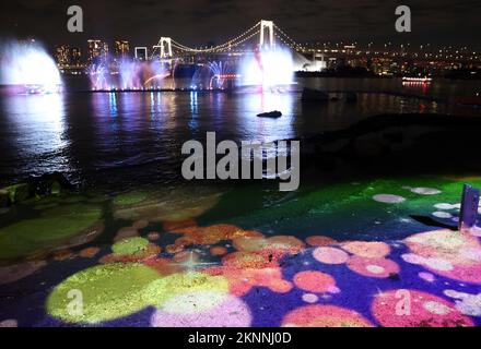 Tokio, Japan. 27.. November 2022. Am Freitag, den 27. November 2022, wird im Daiba am Ufer von Tokio zum ersten Jahrestag der Olympischen und Paralympischen Spiele 2020 ein farbenfroher Springbrunnen- und Projektionsfilm „Tokyo Sparkle Pageant“ auf dem Wasser gezeigt. Die Veranstaltung findet jedes Wochenende bis Ende dieses Jahres statt. Kredit: Yoshio Tsunoda/AFLO/Alamy Live News Stockfoto