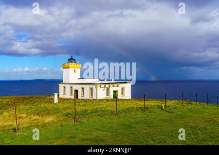Blick auf den Duncansby Head Lighthouse mit einem Regenbogen an der nordöstlichen Spitze von Schottland, Großbritannien Stockfoto