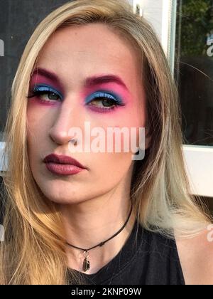 Eine wunderschöne Frau mit pinkfarbenem und blauem Augenschatten. Künstlerisches Make-up Stockfoto