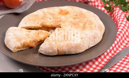 Italienische Küche, Pizza Calzone mit Tomaten, Spinat und Käse auf Holz- Hintergrund. Stockfoto