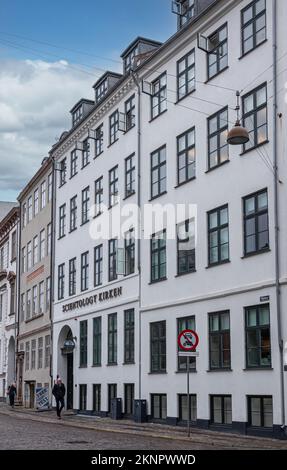 Kopenhagen, Dänemark - 23. Juli 2022: Scientology Kirken, Kirche, weiße Fassade auf Nytorv zwischen anderen Gebäuden mit Fußgängern davor Stockfoto