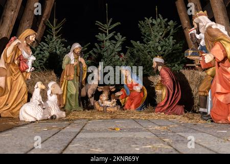 Ein Modell der traditionellen Geburtsszene mit einer heiligen Familie in Bethlehem und dem Jesuskind, das in einer Krippe auf dem Weihnachtsmarkt liegt. Stockfoto