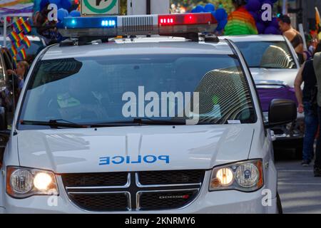 Zwei Polizisten in einem Polizeifahrzeug, die bei der Pride-Parade in Downtown Montreal die Menge kontrollieren. Quebec, Kanada Stockfoto