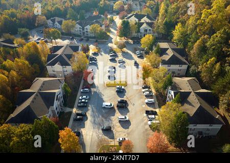 Blick von oben auf Wohnwohnungen zwischen gelben Herbstbäumen in einem Vorort in South Carolina. Amerikanische Häuser als Beispiel für Immobilien Stockfoto