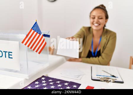 Junge, wunderschöne hispanische Frau, Wahlpräsidentin, die am Wahlkollegium abstimmt Stockfoto