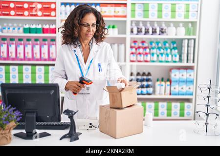 Frau mittleren Alters Apotheker Scannen Pillen Flasche in der Apotheke Stockfoto
