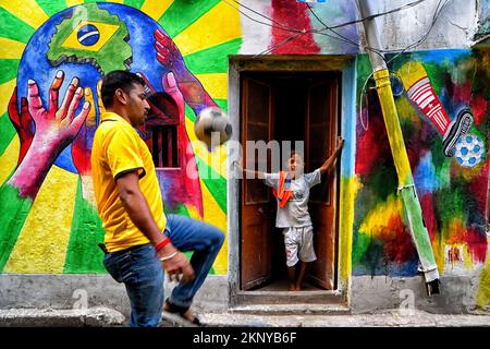 Kalkutta, Indien. 26.. November 2022. Ein Mitglied des Dishari-Clubs hat während der FIFA-Weltmeisterschaft 2022 in Kalkutta Fußball vor Straßenkunst gespielt. Kredit: SOPA Images Limited/Alamy Live News Stockfoto