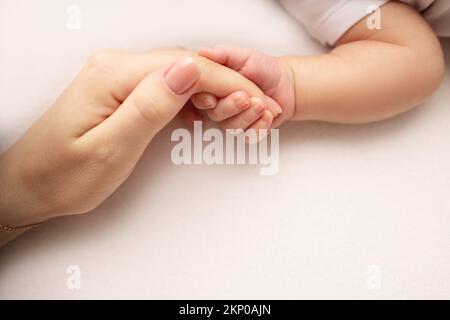 Das neugeborene Baby hat nach der Geburt einen festen Griff am Finger der Eltern. Stockfoto