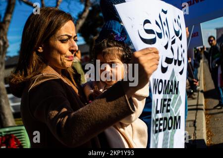 Reno, Usa. 27.. November 2022. Eine Frau und ein Kind nehmen an einem Protest Teil, um die Menschen im Iran zu unterstützen. Die Einheimischen versammeln sich, um ihre Unterstützung für die anhaltenden Proteste im Iran und ihre Wut gegen die iranische Regierung zum Ausdruck zu bringen. Kredit: SOPA Images Limited/Alamy Live News Stockfoto