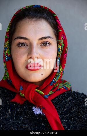 Frau in Babuschka in traditioneller Hochzeitsprozession durch das Dorf Certeze, Satu Mare, Rumänien Stockfoto