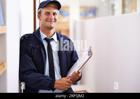 Immer professionell und pünktlich. Ein junger Mann, der eine Lieferung nach Hause macht. Stockfoto