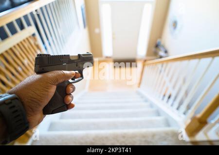 Schutz vor Hausfriedensbruch mit grauem schwarzem Handgewehr Stockfoto