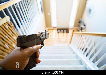 Schutz vor Hausfriedensbruch mit grauem schwarzem Handgewehr Stockfoto