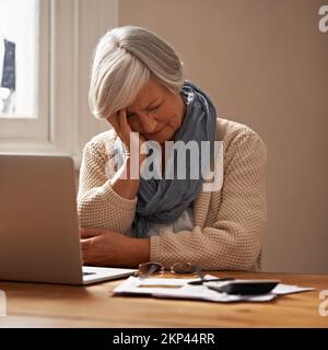 Die Sorge um die Pensionskasse...eine schamlos vor ihrem Laptop sitzende Frau sieht gestresst und besorgt aus. Stockfoto