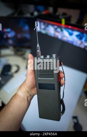 Ein altes grünes Militärfunkgerät wird in einer Hand gehalten Stockfoto