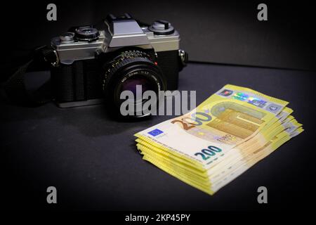 Neben einer alten Reflexkamera liegt ein Stapel 200-Euro-Banknoten Stockfoto