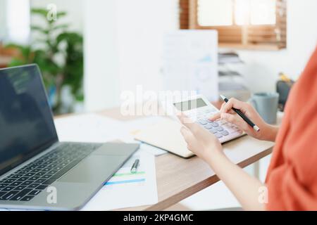 Buchhalter, asiatische Wirtschaftsprüfer verwenden Rechner und Computer, um die jährlichen Steuerbudgets zu überprüfen, um Informationen an das IRS zu übermitteln. Stockfoto