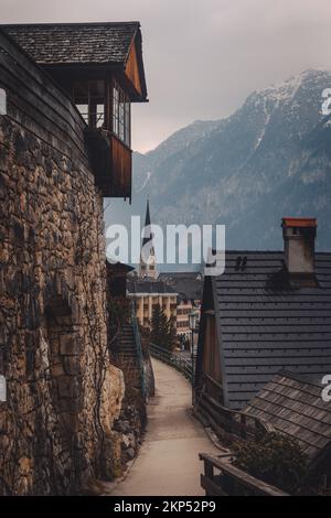 Traditionelle Holzchaletdächer in der Hallstatt-Straße in Österreich mit österreichischen alpen am Horizont Stockfoto