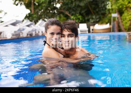 Die Weihnachtsstimmung genießen. Porträt eines attraktiven jungen Paares, das sich im Pool entspannt. Stockfoto