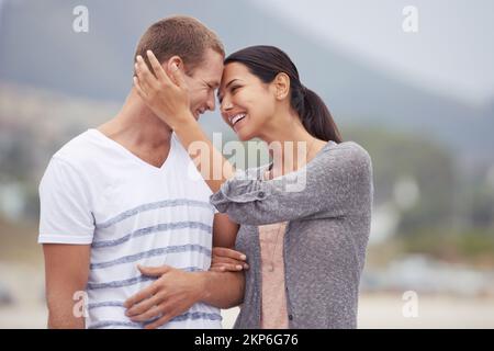 Ich kann meine Augen nicht von dir lassen. Ein liebevolles junges Paar am Strand. Stockfoto