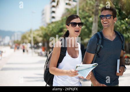 Es gibt so viel zu tun - wo fangen wir an? Zwei junge Touristen, die an einer Promenade spazieren gehen. Stockfoto