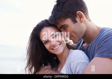 Füreinander geschaffen. Ein liebevolles junges Paar am Strand. Stockfoto