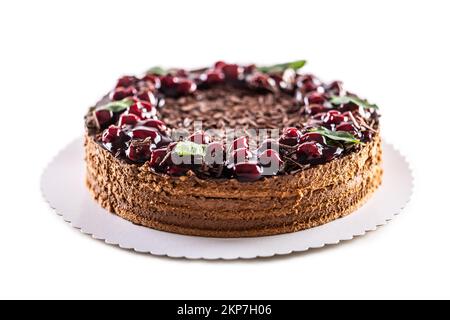 Schokoladen-Kirschkuchen mit Minzblättern auf einem isolierten weißen Hintergrund. Stockfoto
