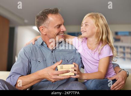 Weil du so besonders für mich bist, Dad. Ein junges Mädchen, das ihrem Vater ein Geschenk macht. Stockfoto