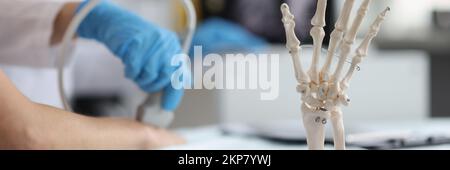 Arzt tun Ultraschall der Hand, Skelett Handmodell auf dem Schreibtisch, medizinische Anatomie Wissenschaft Stockfoto