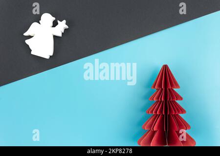 Weihnachtshintergrund mit Origami-Papierbaum auf Papierhintergrund, flach liegend. Stockfoto