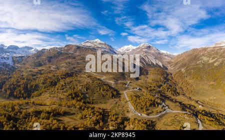 Luftblick über Val Poschiavo mit seinen Lärchenwäldern im Herbstkleid und der Bernina Pass Road, Kanton Graubünden, Schweiz, Europa Stockfoto