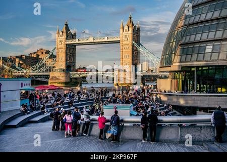 Zuschauer im Scoop Amphitheater mit London City Hall und Tower Bridge über der Themse in der Abendsonne, London, City of London, England, vereinen sich Stockfoto