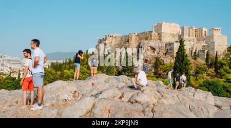 Athen, Griechenland - 29. August 2022: Menschen auf einem Hügel auf der Suche nach dem besten Ort für Fotos vor der Akropolis von Athen, in Gr Stockfoto