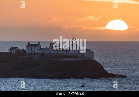 Roches Point, Cork, Irland. 28.. November 2022. Die Sonne steigt hinter Wolken am Roches Point Lighthouse in Cork Harbour, Co Cork, Irland. David Creedon/Alamy Live News Stockfoto