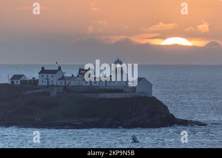 Roches Point, Cork, Irland. 28.. November 2022. Die Sonne steigt hinter Wolken am Roches Point Lighthouse in Cork Harbour, Co Cork, Irland. David Creedon/Alamy Live News Stockfoto