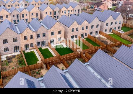 Luftaufnahme von Reihen energiesparender, modularer Reihenhäuser im Neubau in Großbritannien mit charakterlosem Design für Erstkäufer Stockfoto