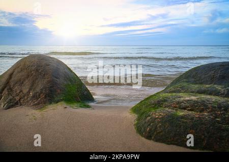 Großer Stein am Sandstrand vor dem Meer mit Wolken am Himmel. Dänemark in Skandinavien. Landschaft aufgenommen aus der Natur im Norden Stockfoto