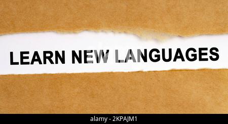 Bildungskonzept. Es gibt eine Lücke in der Mitte des Handwerkspapiers, in dem sich eine Inschrift auf weißem Hintergrund befindet - Neue Sprache lernen Stockfoto