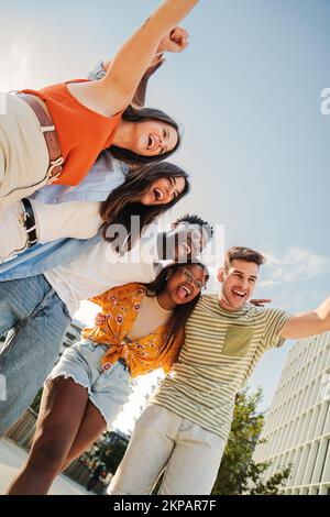 Vertikales Porträt einer Gruppe von lächelnden multiethnischen Teenagern, die Spaß im Freien haben. Nette junge Leute, die im Urlaub zusammen lachen. Lifestyle-Konzept. Hochwertiges Foto Stockfoto